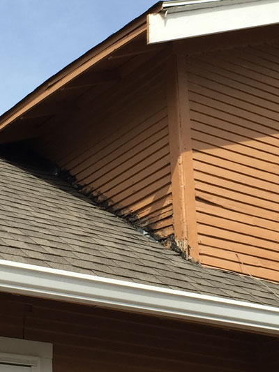 Rotted wood siding along roof line on Omaha house